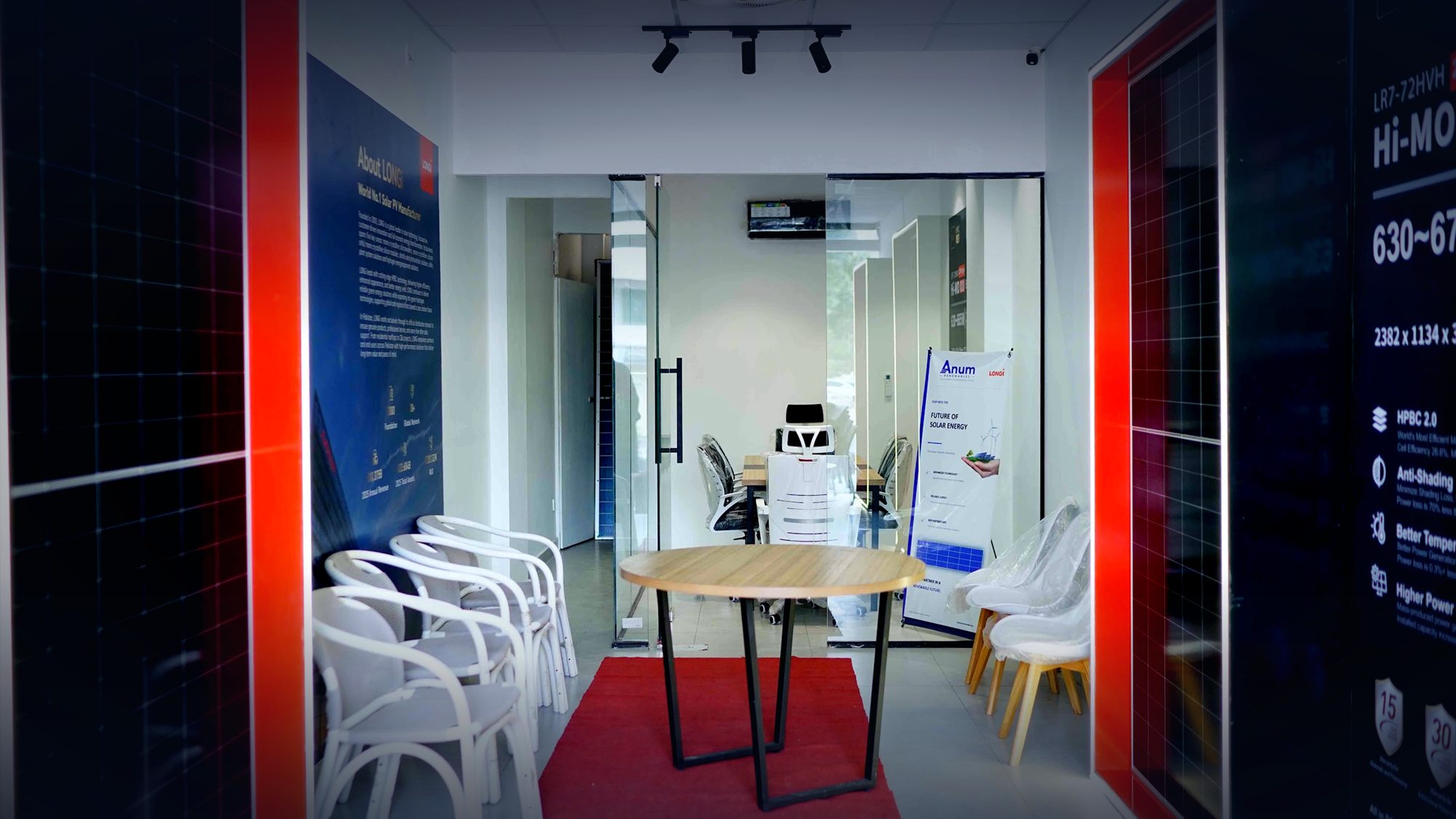 Inside the LONGi Experience Store: solar panels in lit red frames, a round table on a red carpet and a glass-walled meeting room