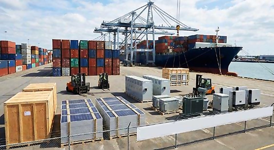 Solar panels and electrical cabinets on pallets at a container port