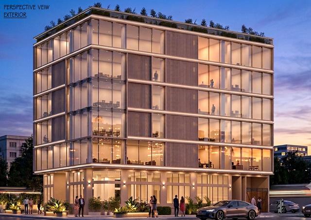 Seven-storey glazed office building with a planted roof, shown at dusk
